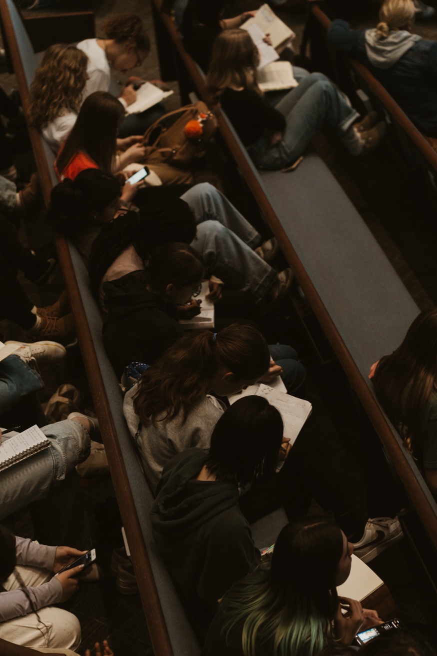 Audience members in pews taking notes